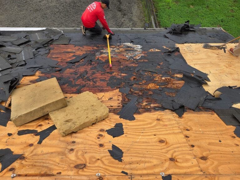 Roofing crew replacing an asphalt shingle roof on a Toms River NJ colonial with underlayment and ice and water shield exposed