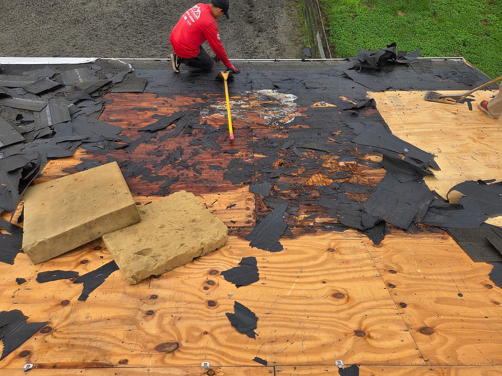 Roofing crew replacing an asphalt shingle roof on a Toms River NJ colonial with underlayment and ice and water shield exposed