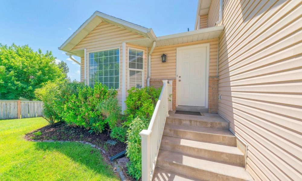 White front door near the vinyl wood siding of a house in Utah